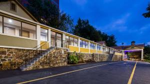 a building with a stone wall next to a street at Best Western Fort Lee in Fort Lee