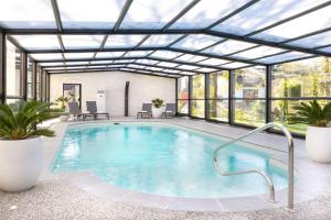 une piscine intérieure avec un toit rétractable dans l'établissement Hotel Best Western La Mare O Poissons, à Ouistreham