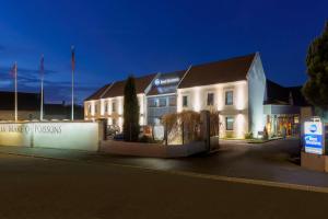 a white building with a sign in front of it at Hotel Best Western La Mare Ô Poissons in Ouistreham