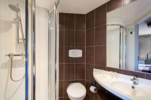 a bathroom with a toilet and a sink and a shower at Hotel Best Western La Mare Ô Poissons in Ouistreham