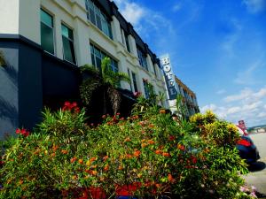 a hotel with flowers in front of a building at Hotel 138 @ Subang in Shah Alam