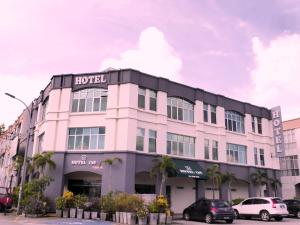 een hotelgebouw met auto's die ervoor geparkeerd staan bij Hotel 138 @ Subang in Shah Alam