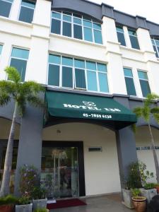 a building with a green awning and palm trees at Hotel 138 @ Subang in Shah Alam