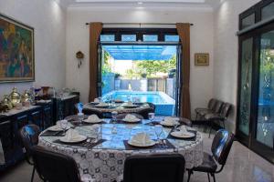 a dining room with a table and a swimming pool at Salak Cozzy Stay Managed by Salak Hospitality in Kamparganya
