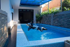 a pool with a toy shark in the middle of it at Salak Cozzy Stay Managed by Salak Hospitality in Kamparganya