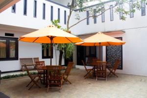 a patio with tables and chairs with umbrellas at Salak Cozzy Stay Managed by Salak Hospitality in Kamparganya