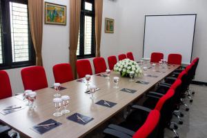 a conference room with a long table and red chairs at Salak Cozzy Stay Managed by Salak Hospitality in Kamparganya +9 photos