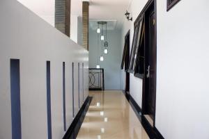 a hallway with white walls and white floors and a staircase at Salak Cozzy Stay Managed by Salak Hospitality in Kamparganya