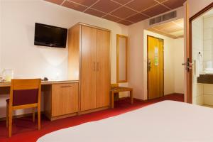 a hotel room with a bed and a television at Campanile Metz Nord - Talange in Talange
