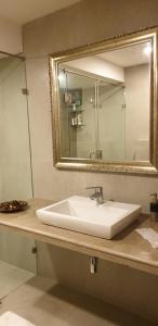 a bathroom with a white sink and a mirror at Eternal wave by HappyInch in Calangute
