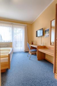 a hotel room with a desk and a bed at Hotel Papp-Mühle in Zersen