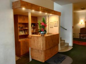 a lobby with a counter with a flower vase on it at Hotel Hansa in Offenbach