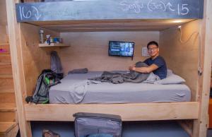a man sitting on top of a bunk bed at PodShare DTLA in Los Angeles