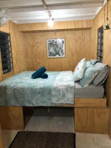 a bed in a room with a wooden wall at SEA-green in Nelly Bay