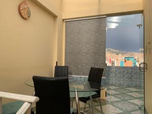 comedor con mesa de cristal y sillas en Residencial Alta Vista, en La Paz