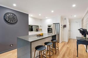 a kitchen with a counter and a clock on the wall at Darling Harbour Getaway in Sydney