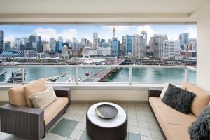 a balcony with two couches and a view of a city at Darling Harbour Getaway in Sydney