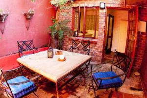 una mesa de madera y sillas en un patio en Bamboo, the Guesthouse, en Knysna