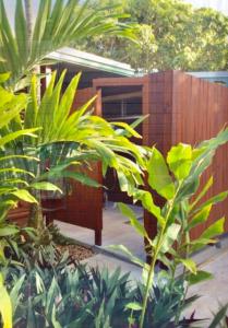 un jardín con plantas verdes y una valla de madera en Kalani Hawaii Private Lodging en Pupukea