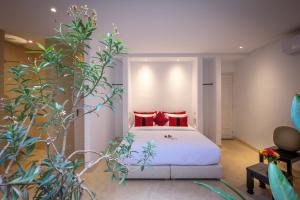 a bedroom with a white bed with red pillows at Ryad Marrakech in Marrakesh