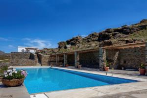 a villa with a swimming pool in front of a mountain at Evita's Villas-Tinos in Tinos
