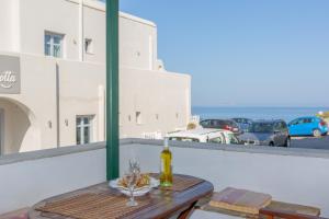 uma mesa com uma garrafa de vinho e copos numa varanda em Irida Holiday Home em Naxos Chora
