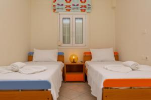 2 camas individuais num quarto com uma janela em Irida Holiday Home em Naxos Chora