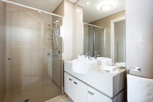 een badkamer met een glazen douche en een wastafel bij The Junction Palais - Modern and Spacious 2BR Bondi Junction Apartment Close to Everything in Sydney