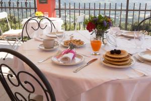 uma mesa com uma toalha de mesa branca com alimentos para o pequeno-almoço em B&B Spring em Perugia