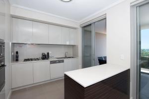 een keuken met witte kasten en een aanrecht bij The Junction Palais - Modern and Spacious 2BR Bondi Junction Apartment Close to Everything in Sydney