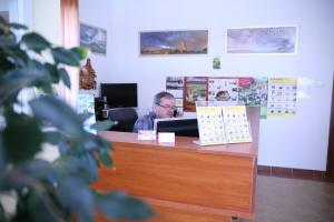 un hombre sentado en un escritorio en una oficina en Willa Sudety en Karpacz