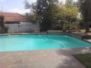 a swimming pool with a hose in a yard at Fourways Johannesburg Hostel in Johannesburg