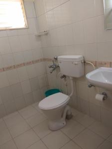 a bathroom with a toilet and a sink at Vega Residency in Bangalore