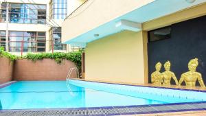 a swimming pool with statues on the side of a building at Kandy View Hotel in Kandy