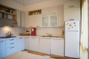 cocina con armarios blancos y nevera blanca en Affittacamere " Il Porto ", en Livorno