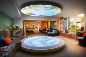 a large room with a bath tub in the middle of it at Göbel`s Hotel Quellenhof in Bad Wildungen