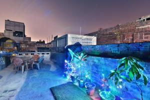 a rooftop patio with blue lights and plants on it at Wow Backpackers Hostel in Amritsar