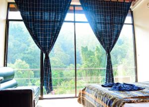 una camera da letto con un letto e una grande finestra di Kandy View Hotel a Kandy