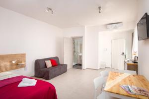 a bedroom with a bed and a chair and a table at Island Guesthouse in Il-Gżira