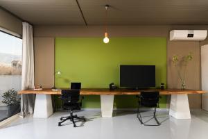 an office with a green wall and a desk with a television at 5* Penthouse Acropoli View Loft in Athens