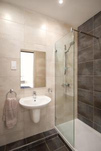 a bathroom with a sink and a glass shower at Island Guesthouse in Il-Gżira