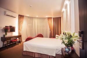 a hotel room with a bed and a desk at Dinh Hotel in Hanoi