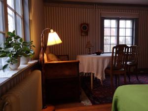 um quarto com uma mesa, uma cadeira e um candeeiro em Stockholm B&B Cottage em Nacka