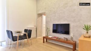 ein Wohnzimmer mit einem Tisch und einem TV an der Wand in der Unterkunft Pangea Suite - Vaticano in Rom