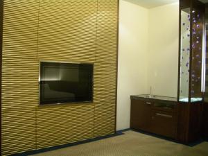 um quarto com uma televisão na parede em Hip Spa Motel em Wuri