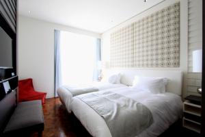 a bedroom with a large white bed and a window at Umito Voyage Atami in Atami