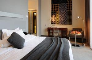 1 dormitorio con 1 cama grande, mesa y mesa en Kabadoni Boutique Hotel, en Signagi