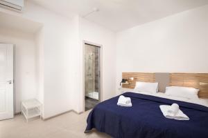 a bedroom with a bed with two towels on it at Island Guesthouse in Il-Gżira