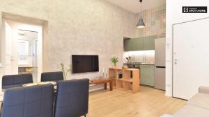ein Wohnzimmer mit einem Sofa und einem TV sowie eine Küche in der Unterkunft Pangea Suite - Vaticano in Rom