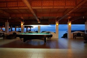 una mesa de billar en una habitación con vistas al océano en Kasai Village Dive Resort, en Moalboal
